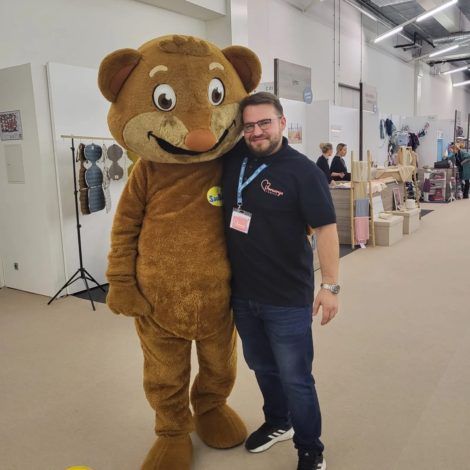 Berater von Vorsorge Familie mit einem Bären-Maskottchen auf der Messe