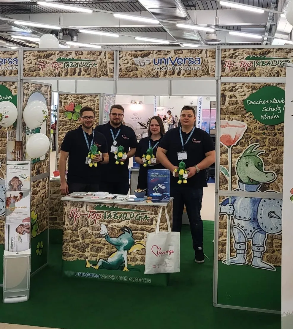 Das Team von Vorsorge Familie vor seinem Messestand